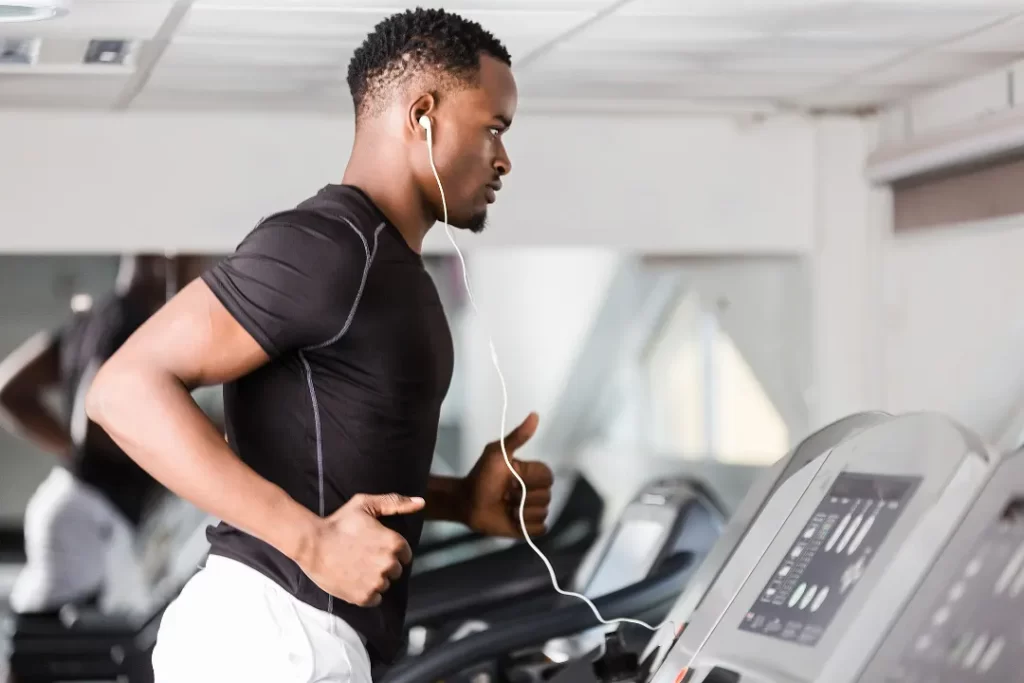 young black man running on a treadmill in the gym.