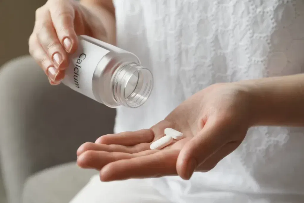 Woman intaking calcium supplements for healthy bones. 