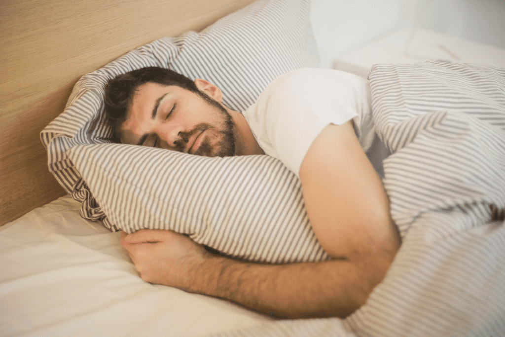 Young bearded man sleeping on the bed.