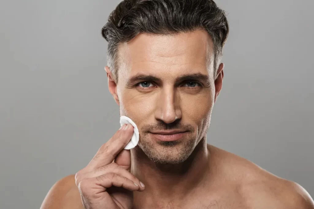 attractive man applying moisture lotion for hydrating his skin. 