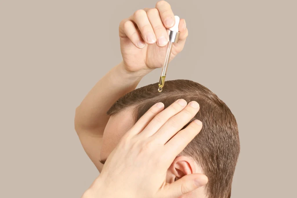 Man applying hair serum for healthy hair. 