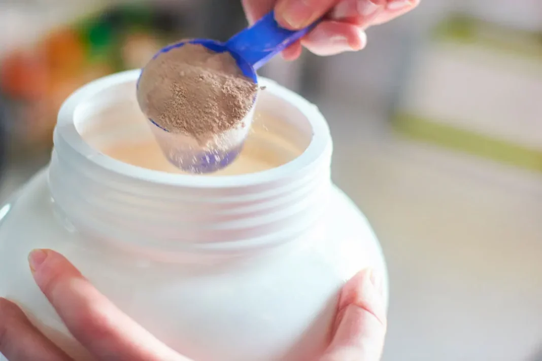 measuring out protein powder with measuring scoop