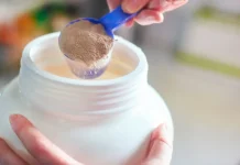 Level 1 Protein Powder vs Nuzest Clean Lean Protein measuring out protein powder with measuring scoop