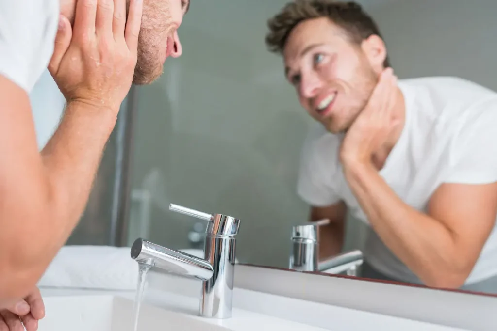 Man washing his face and neck. 